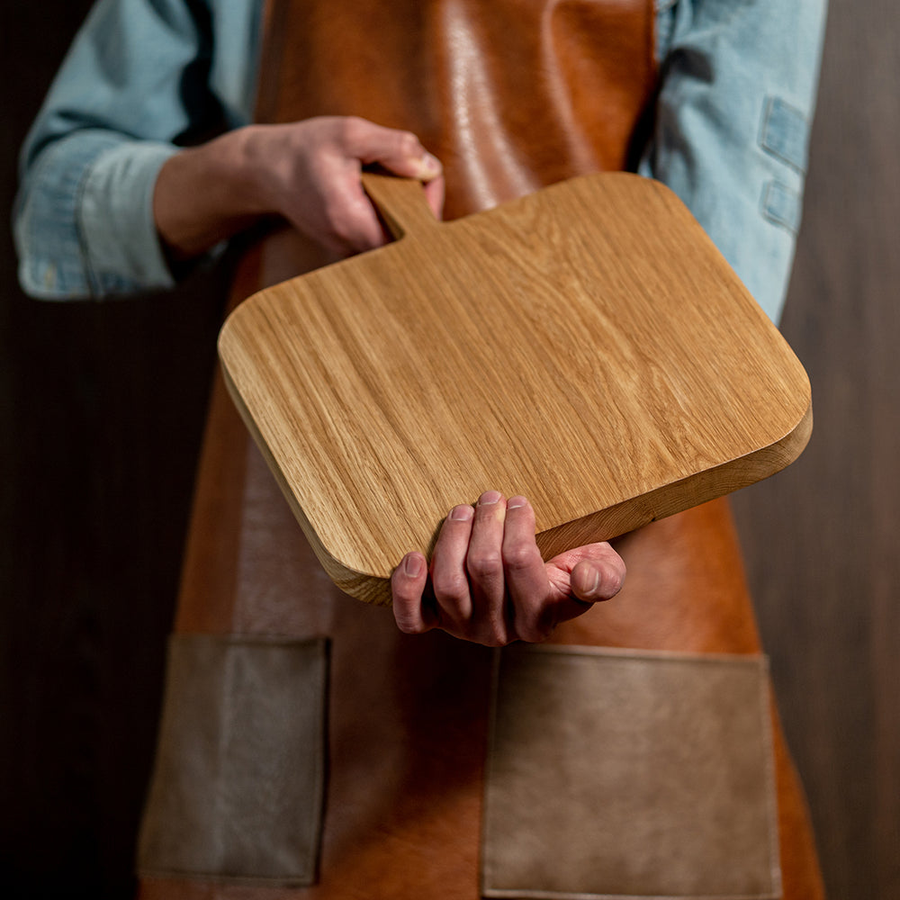 chef holding wooden cutting board, made of solid wood oak