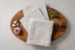 pale sandy set of 3 linen tea towels on the oak wood cutting board
