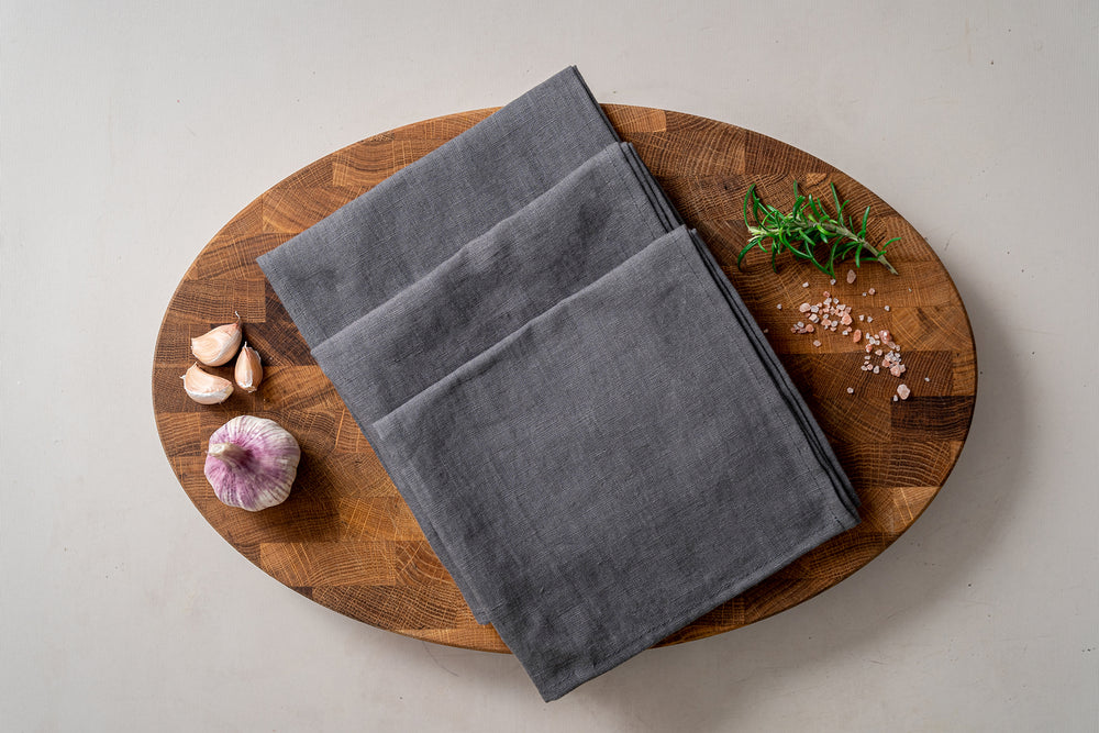 grey linen kitchen towels on the wooden cutting board